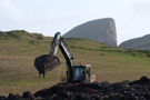 Looking like a prehistoric monster, the excavator landscapes the spare soil